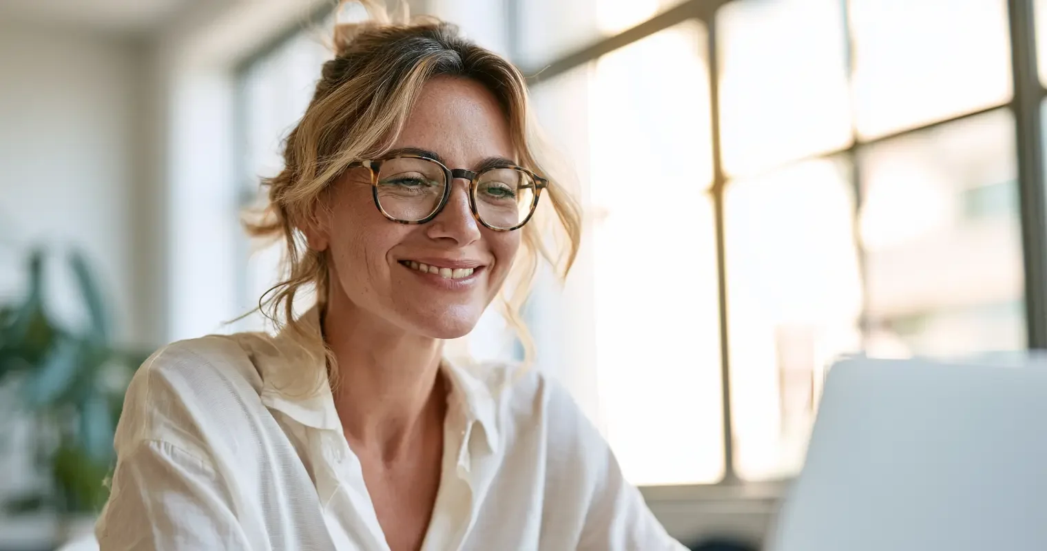 Naples business owner reviewing search results on a laptop in a bright airy office in warm daylight, editorial documentary portrait
