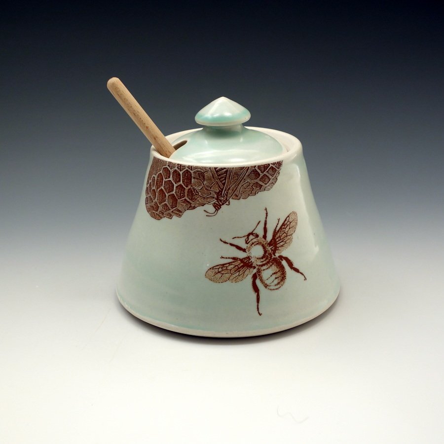 Celadon glazed porcelain honey pot with bees buzzing and honey comb