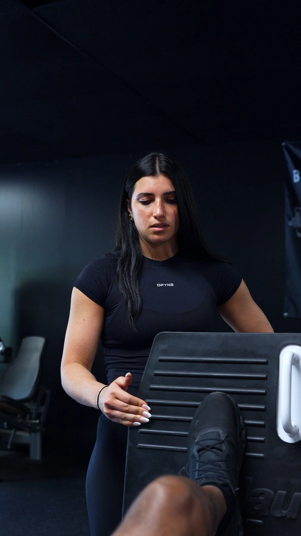 Mary Valenzano coaching a client through a leg press exercise