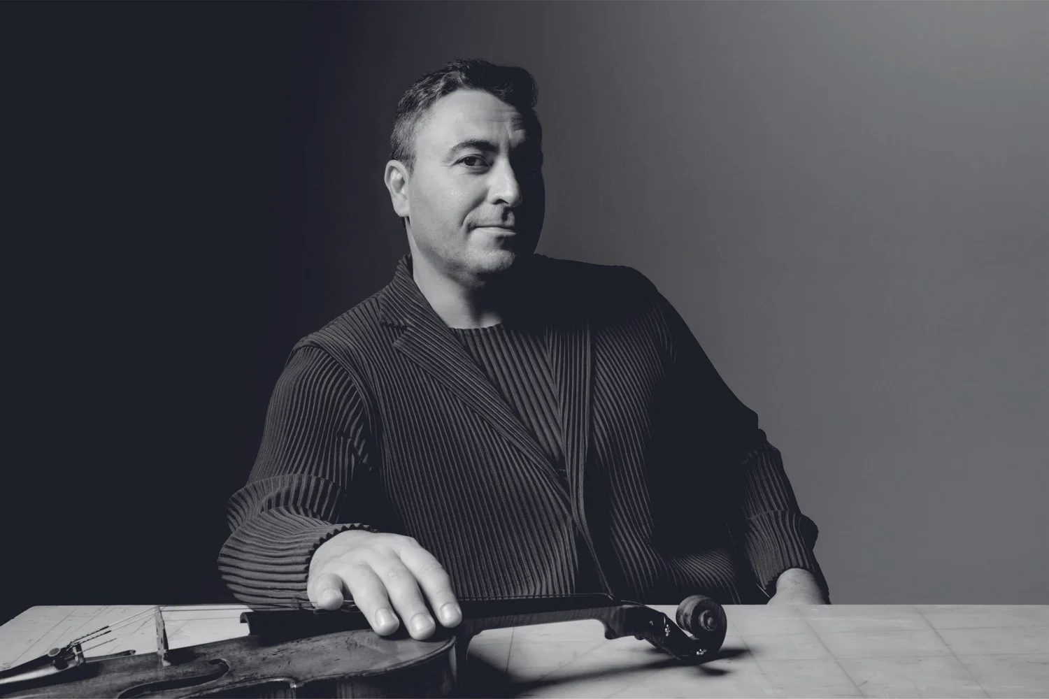 Maxim Vengerov seated with his violin