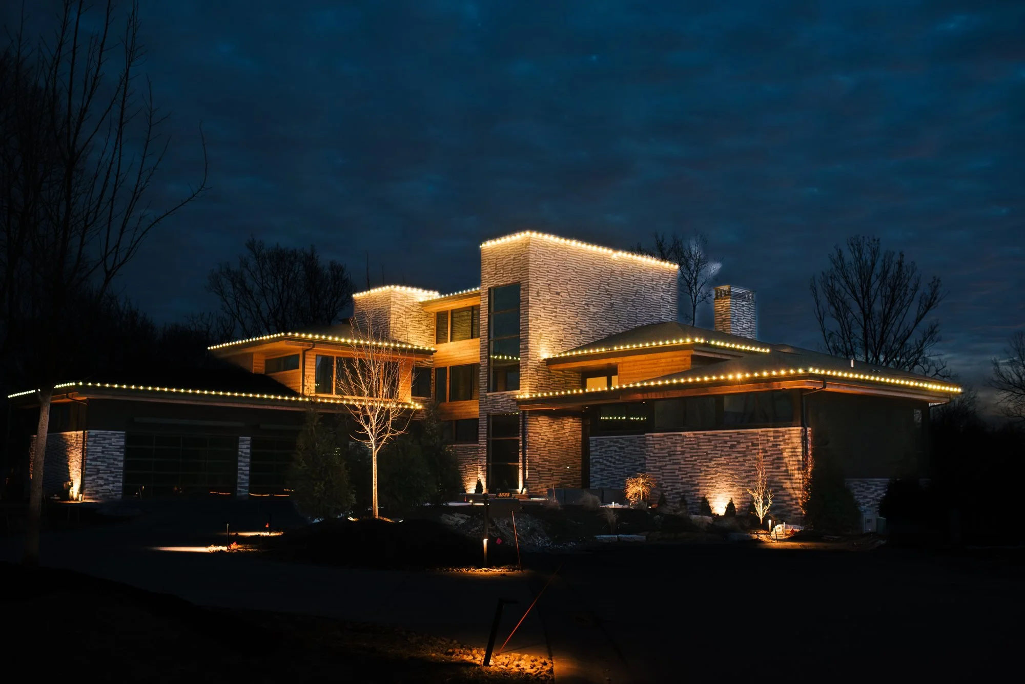 Modern home outlined in permanent warm white lighting at dusk