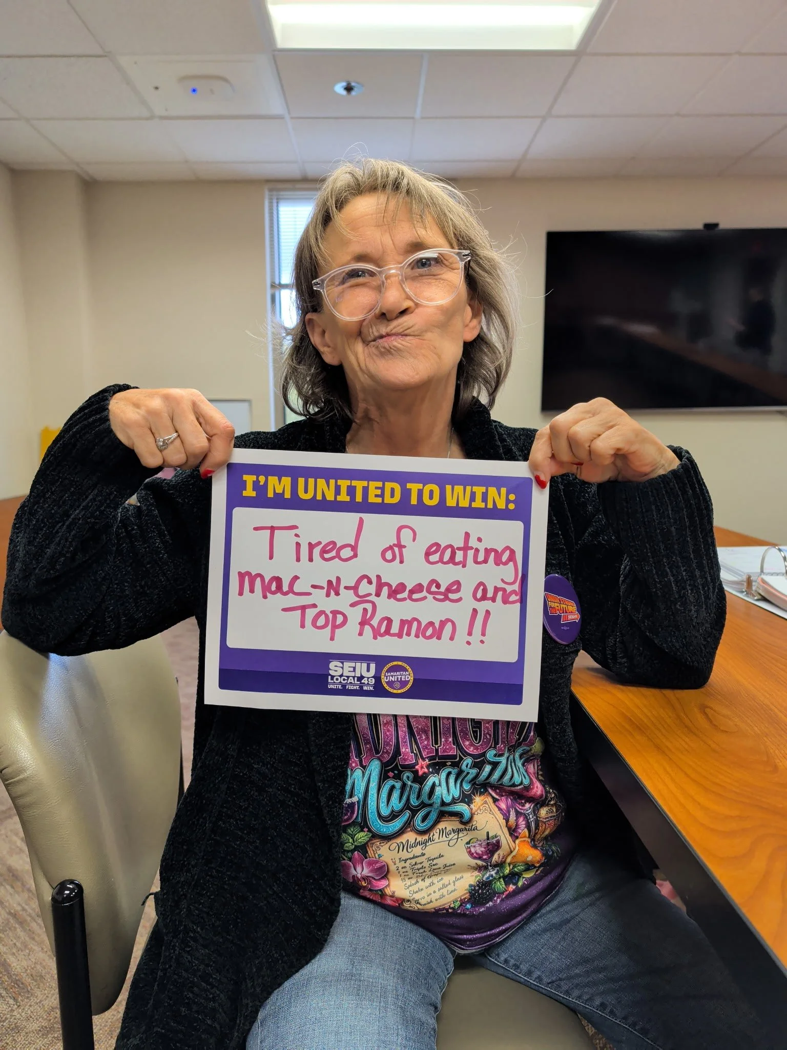 A member holds a sign that reads: “I’m united to win: Tired of eating mac-n-cheese and Top Ramen!!”