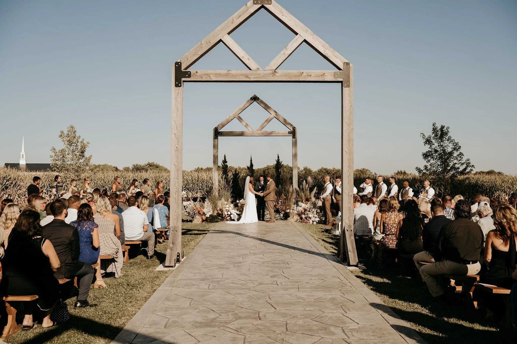 Wedding ceremony with guests gathered along the outdoor 75-foot aisle