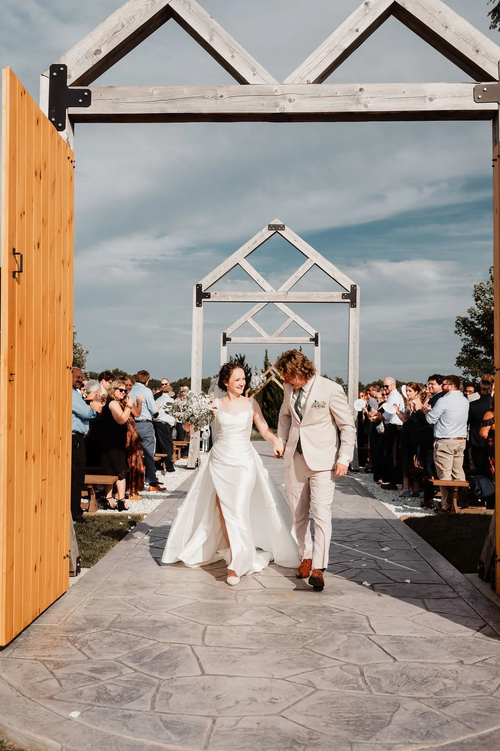 Wedding ceremony with guests gathered along the outdoor 75-foot aisle