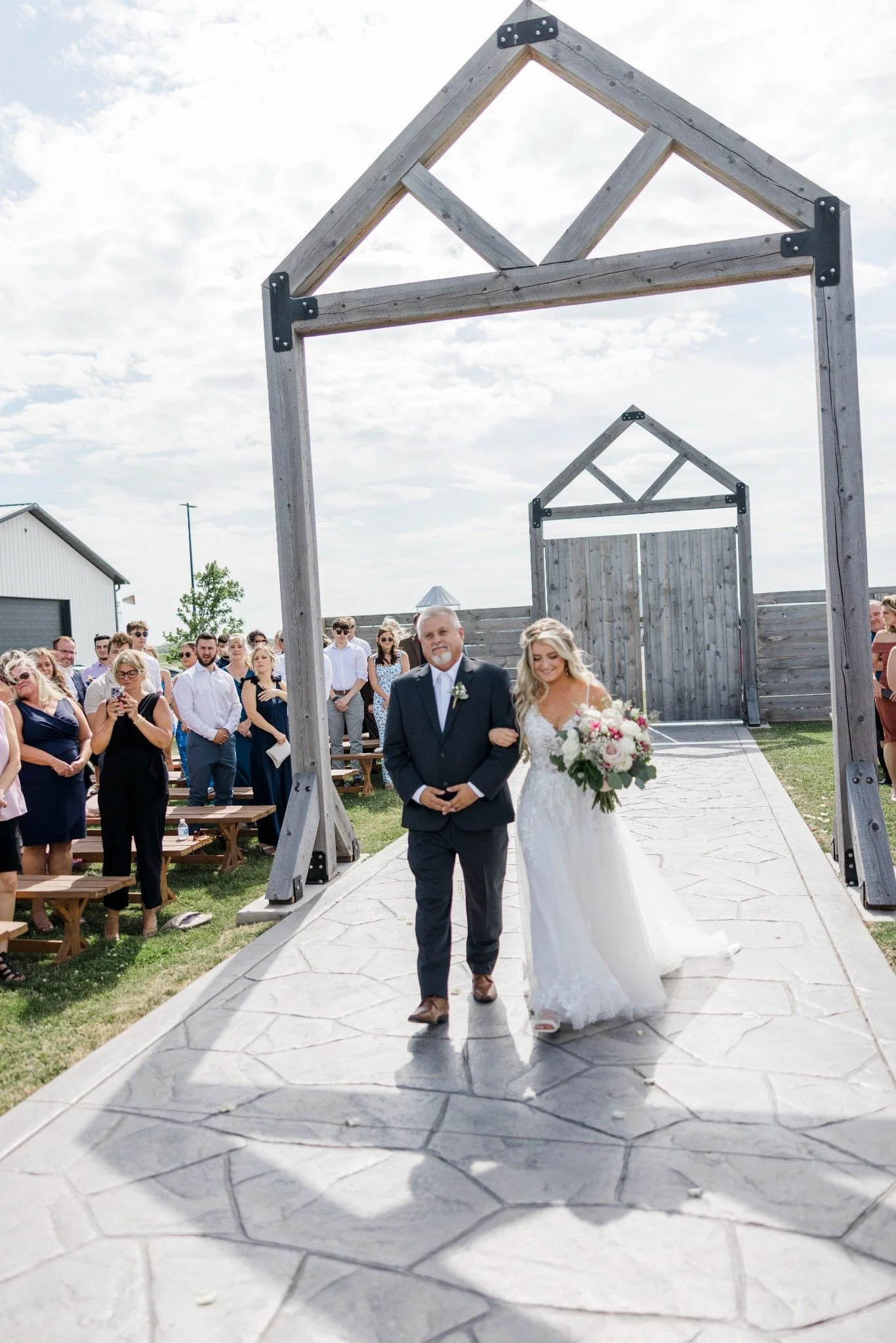 Wedding ceremony with guests gathered along the outdoor 75-foot aisle
