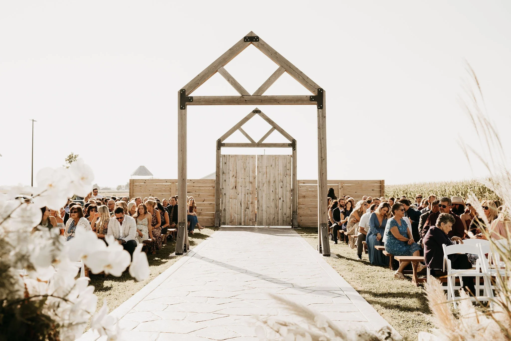 Wedding ceremony with guests gathered along the outdoor 75-foot aisle