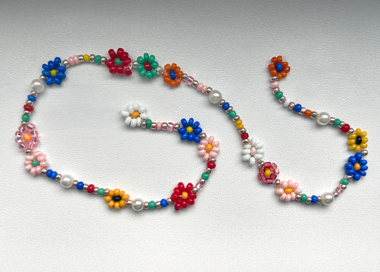 A strand of colorful beads against a white backdrop. 
