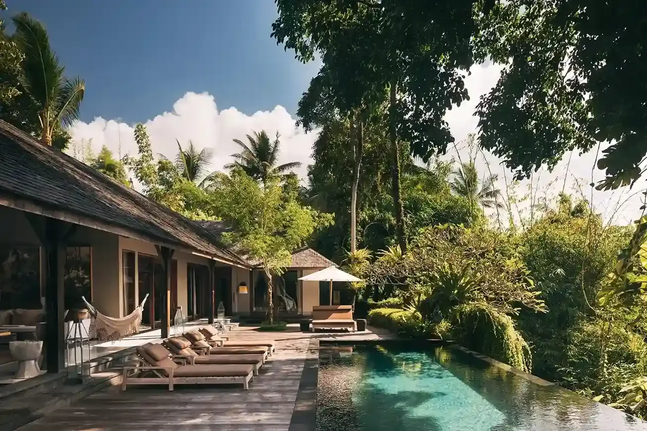 Heated saltwater pool of Rumah Hujan I in daylight, surrounded by tropical garden, Ubud