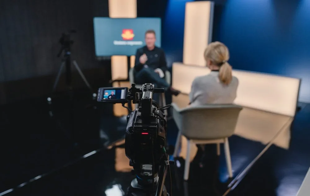 Kamera i fokus som filmer personer i studio som er litt blurry