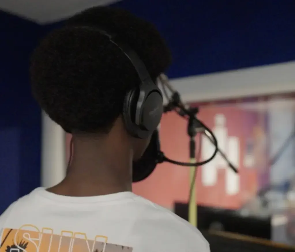 A young person speaking into the microphone in our music studio