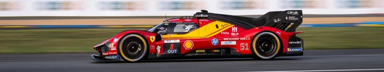Red and yellow number 51 Ferrari racing at Le Mans, with motion-blurred scenery.
