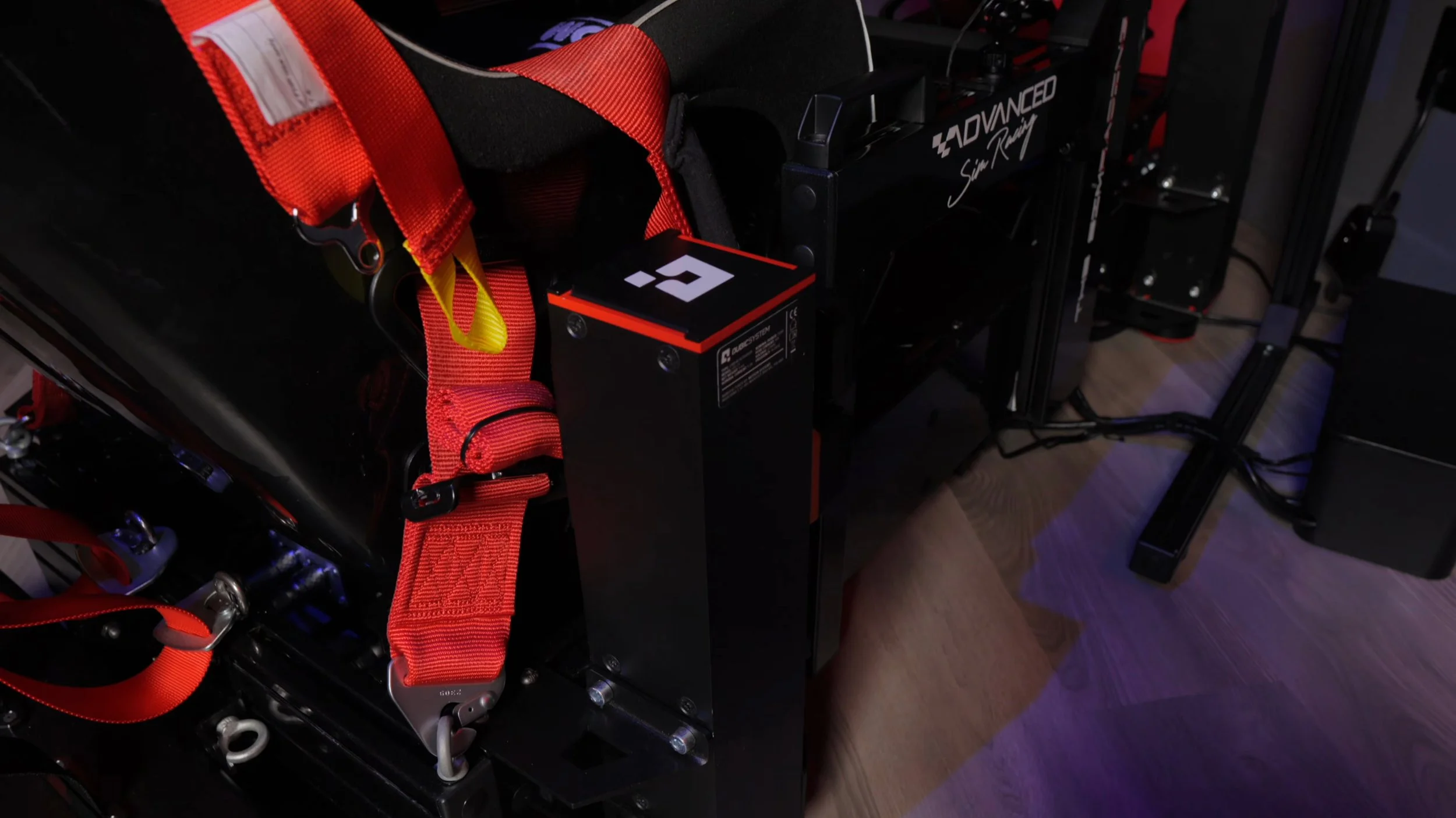 An installed QS-210 actuator beside the seat and harness.