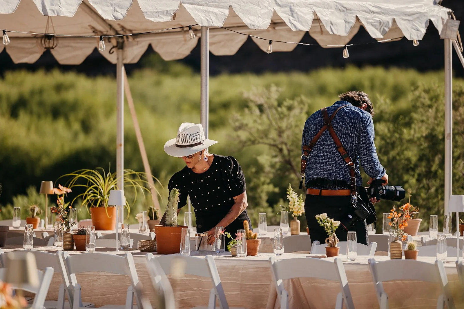 A wedding planner sketching at a table at sunset with a glass of rosé