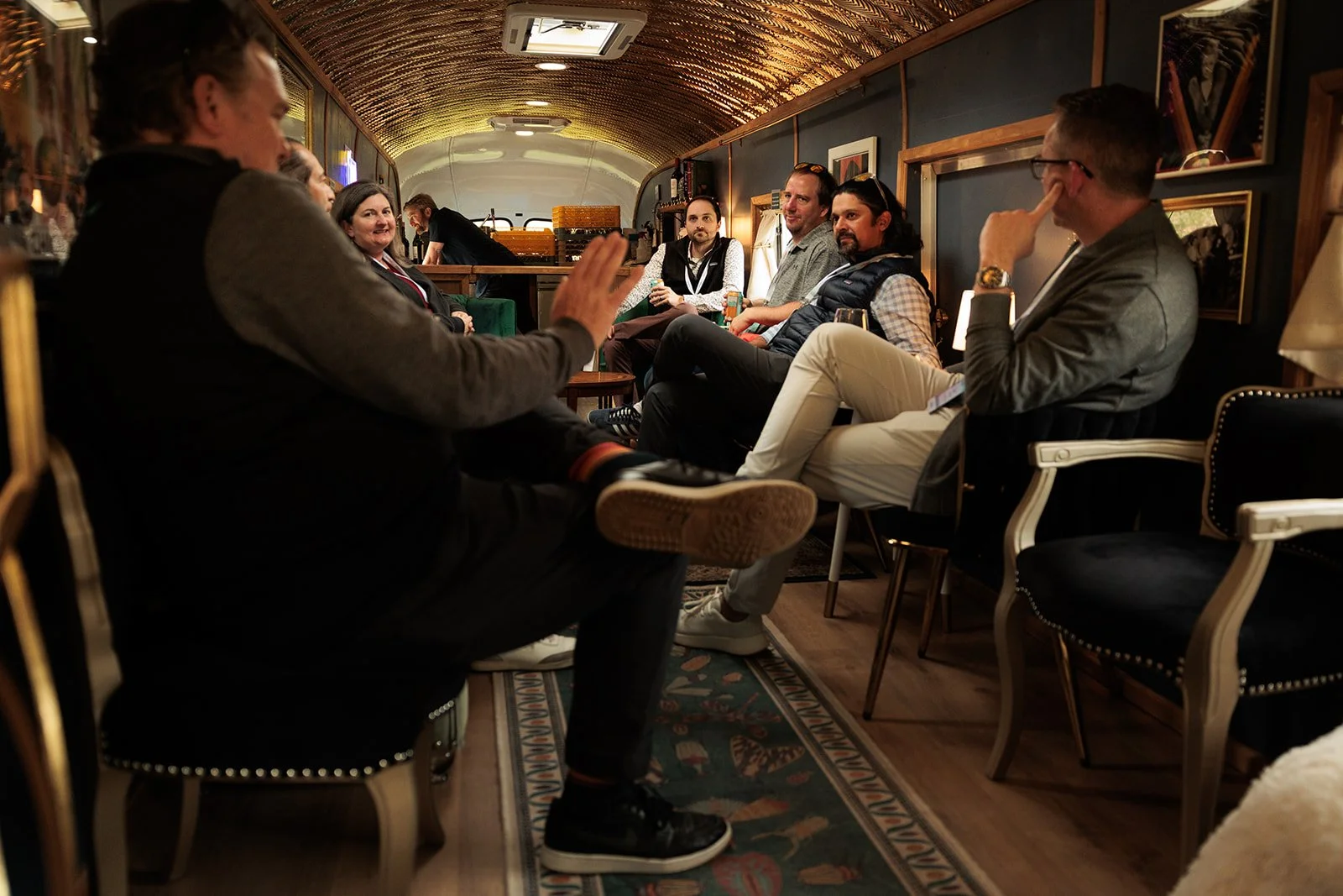 Guests toasting craft cocktails inside the vintage bus lounge