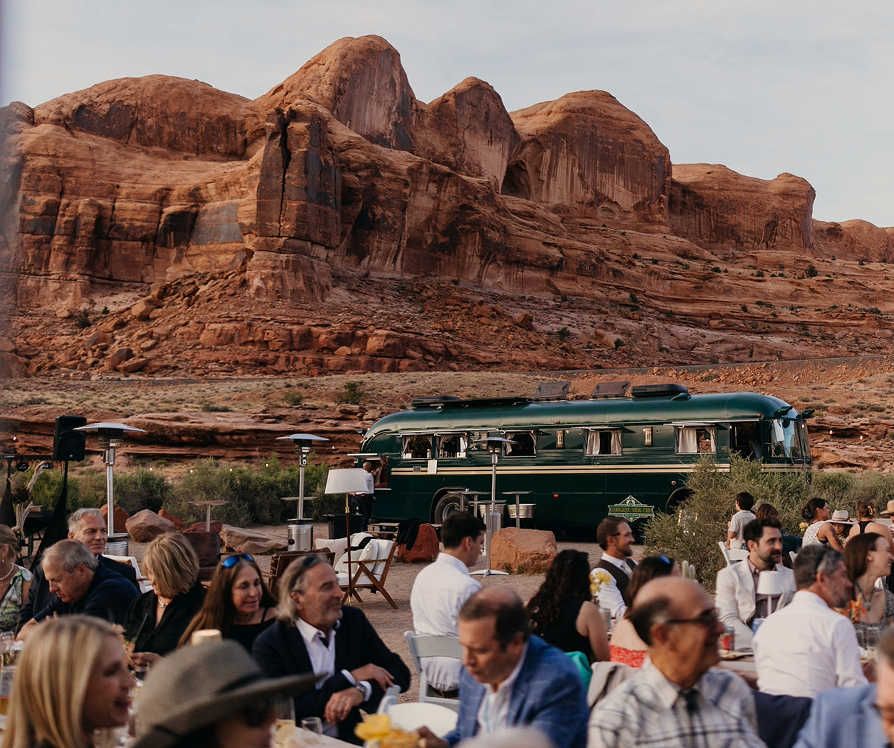 An intimate outdoor rehearsal dinner scene set against Moab's red rock landscape