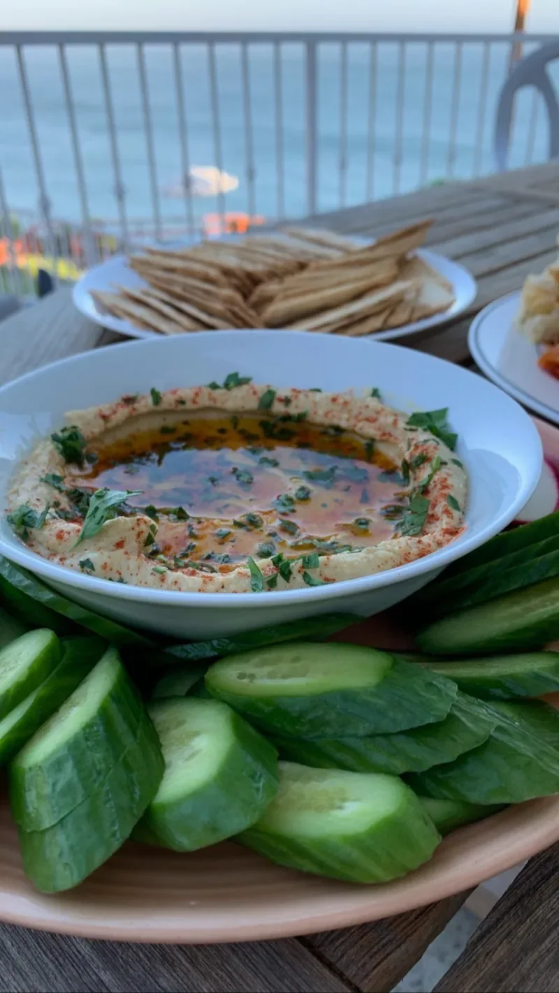 A bowl of dip with herbs, cucumber and flatbread prepared by Chef Collin.