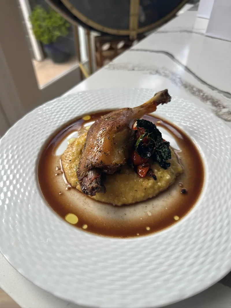 A plated main course with sauce and vegetables from Chef Collin’s cooking