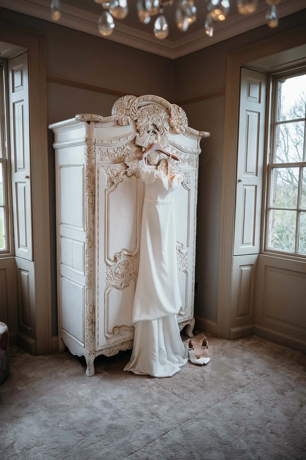 Wedding dress hanging on an ornate wardrobe in the bridal suite at Newton Hall
