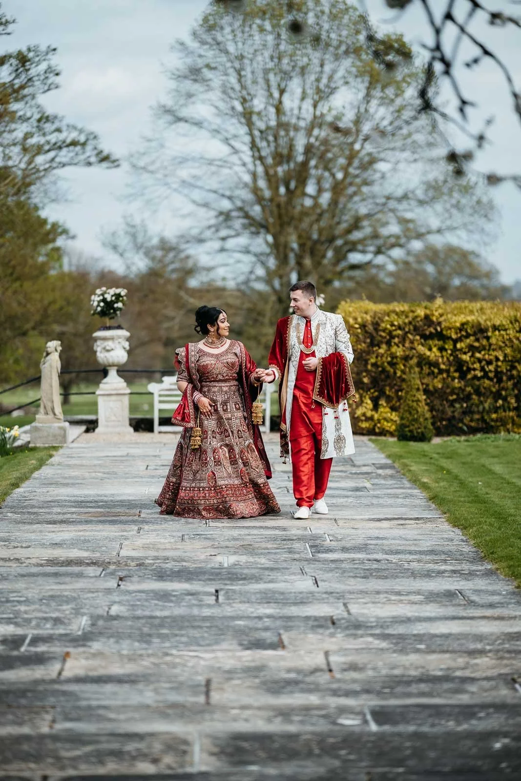 Couple walking along the long stone path through the gardens at Lartington Hall