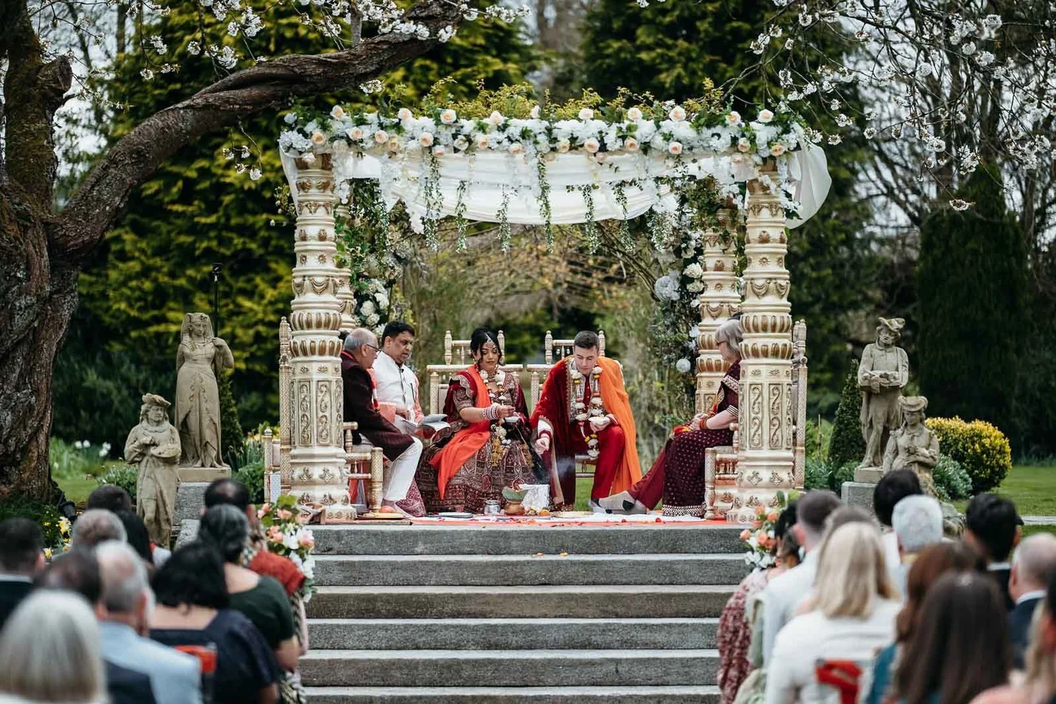 Wide view of a garden ceremony at Lartington Hall, guests seated below the stone steps
