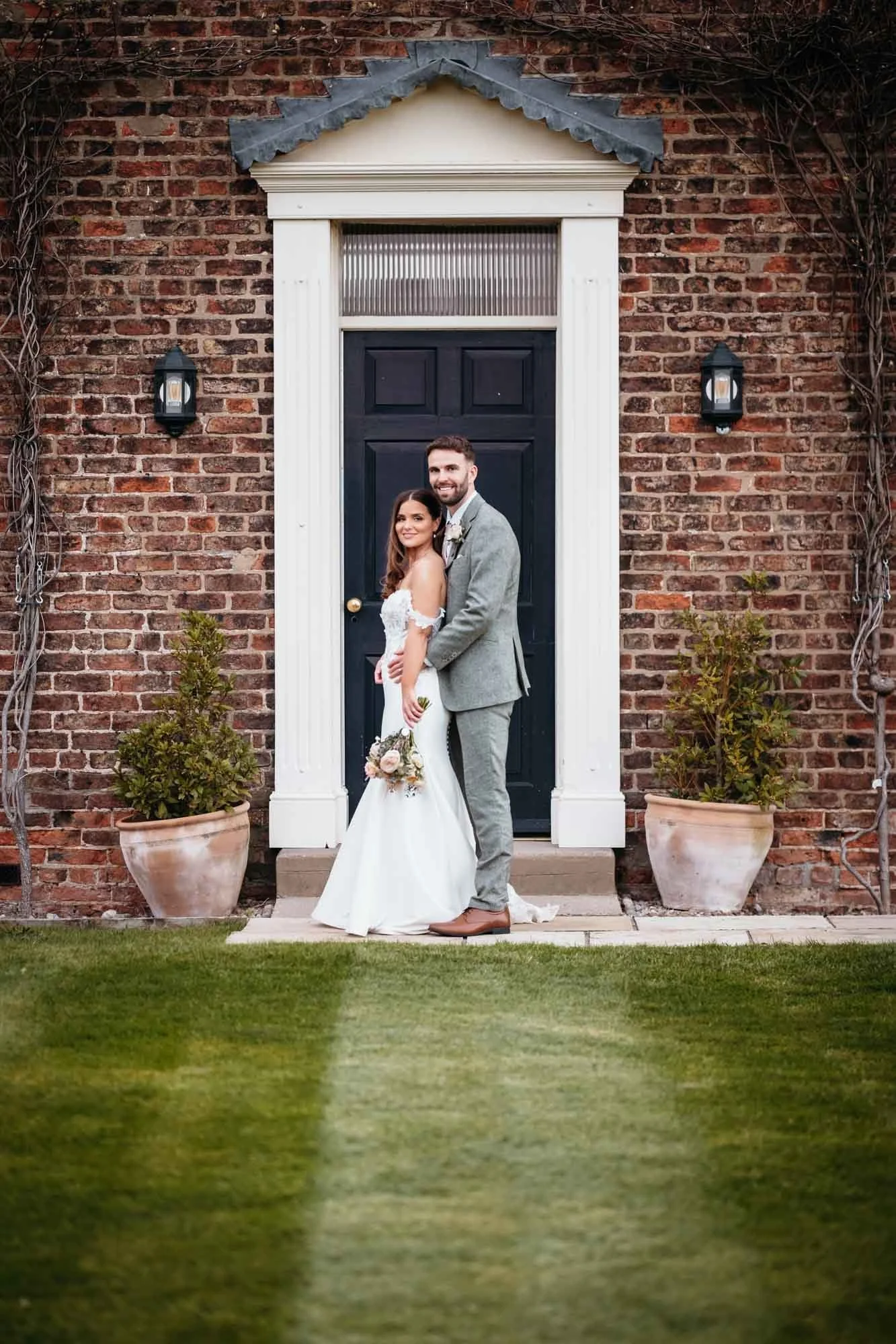 Couple at the Georgian front door of the farmhouse at Thirsk Lodge Barns