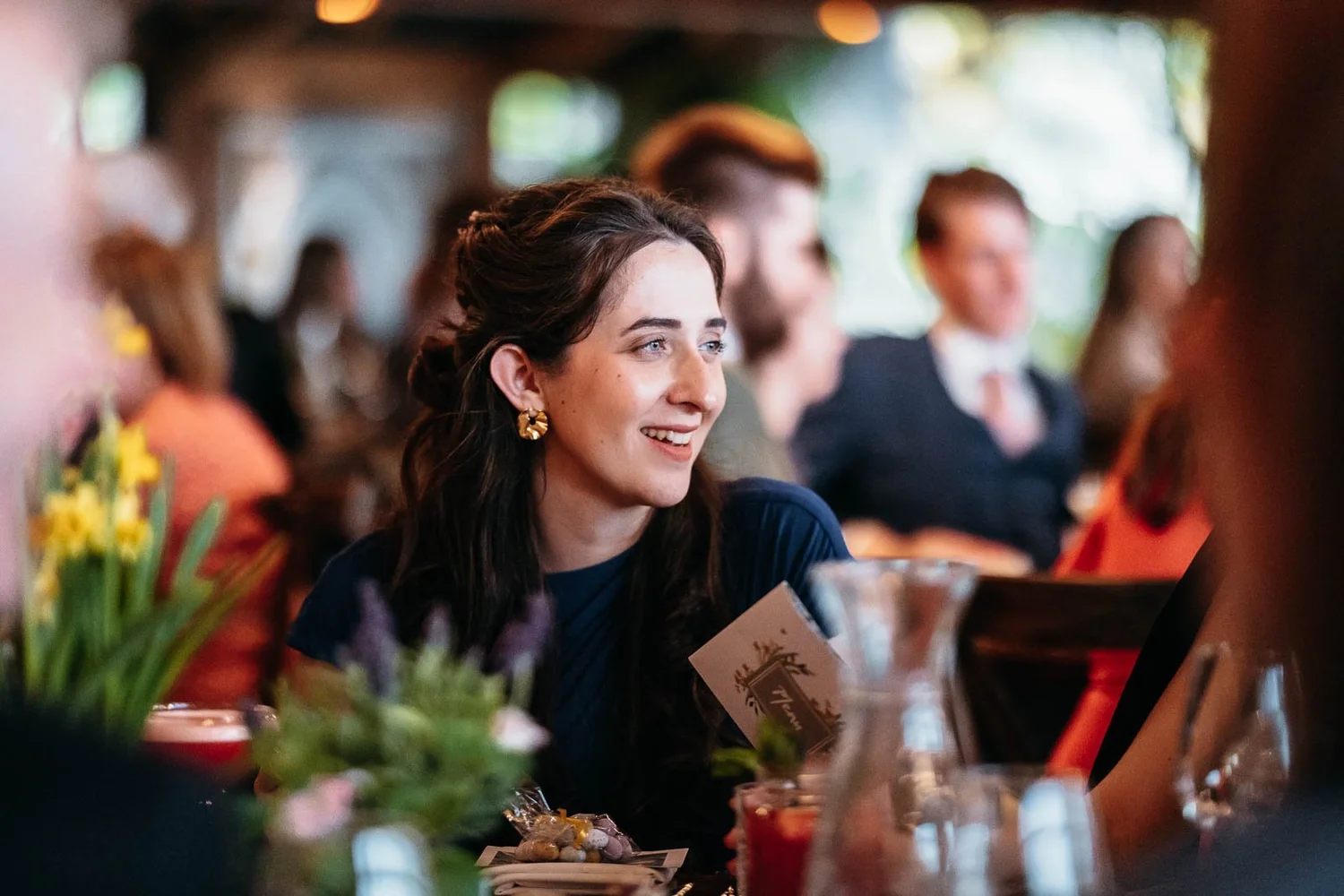 Guests laughing at their tables during the reception at Newton Hall