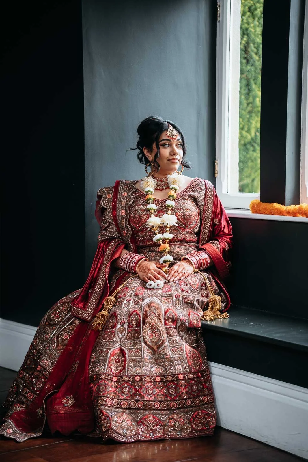 Bride seated in a window bay in soft natural light at Lartington Hall