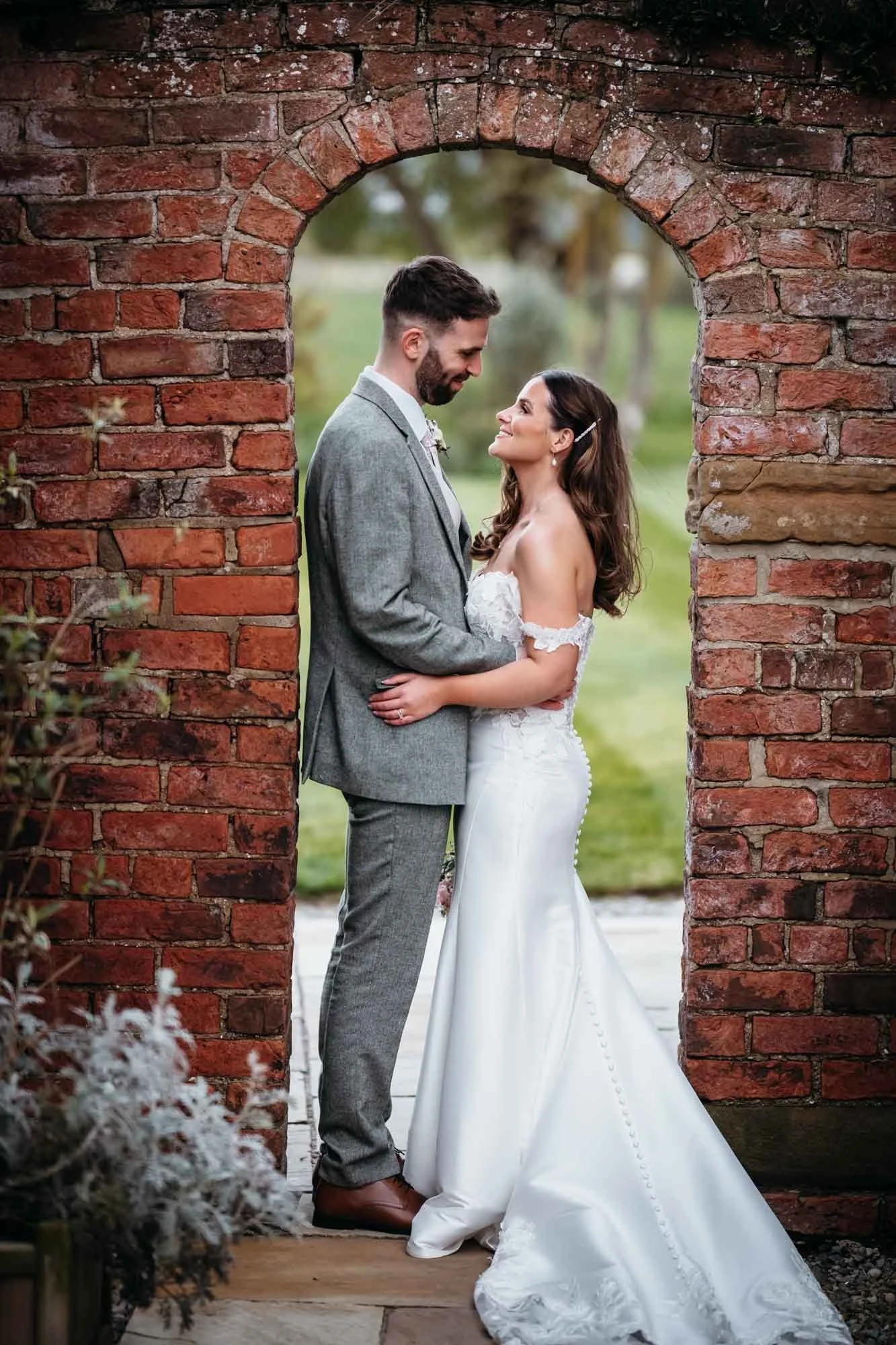 Couple framed in an old brick archway at Thirsk Lodge Barns