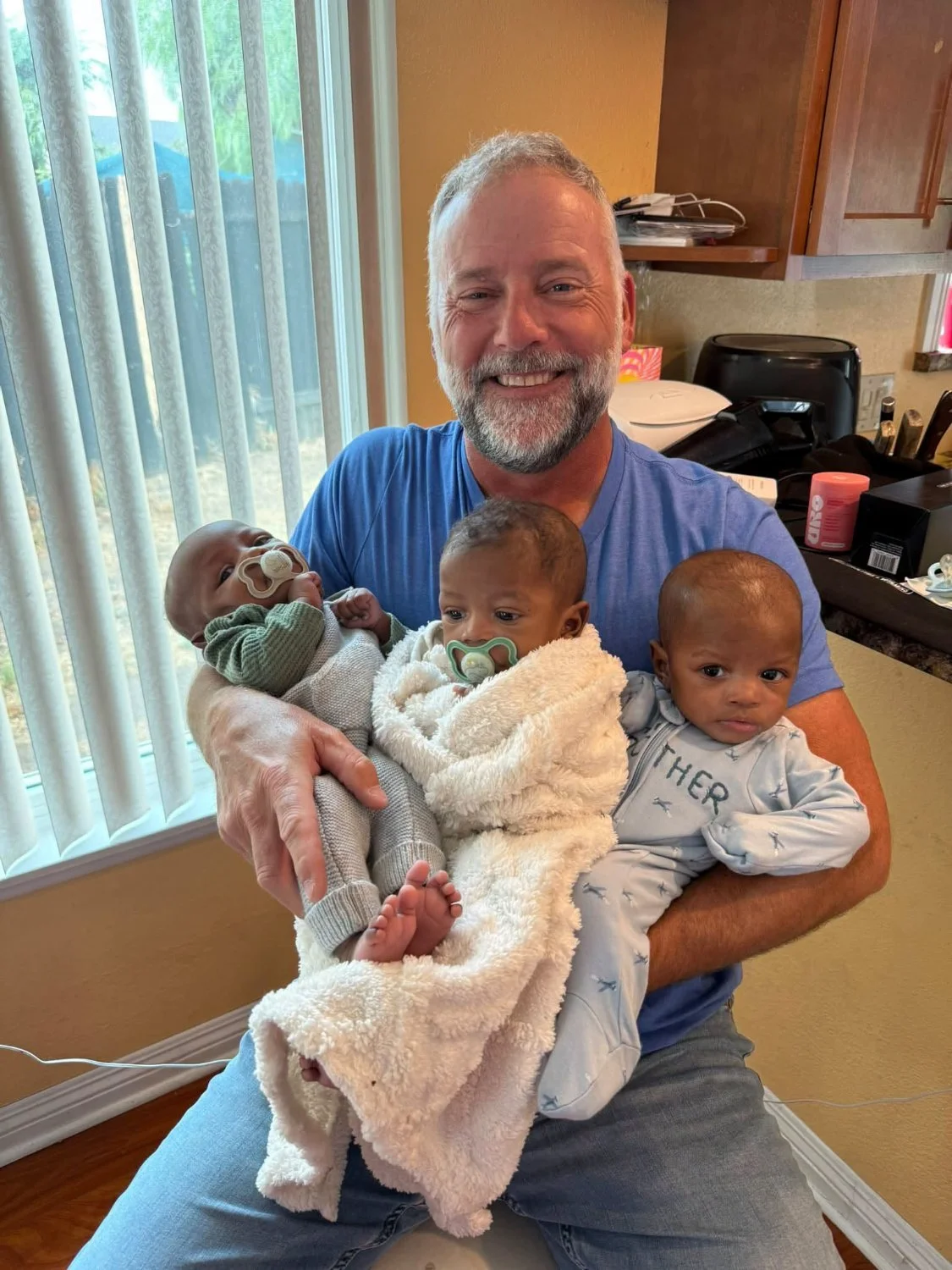 Scott holding the triplets