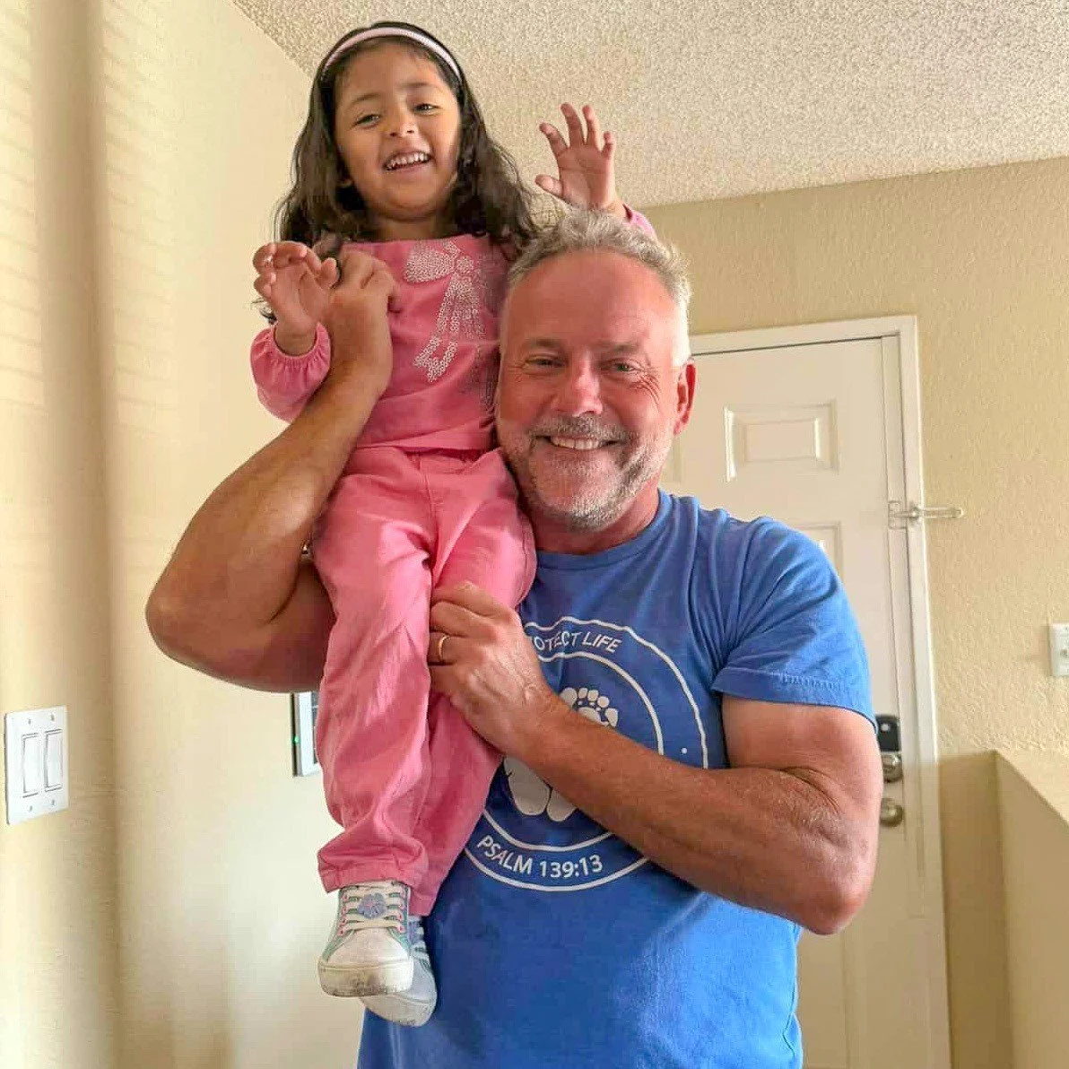 A little girl whose mom chose life, laughing on Scott’s shoulder