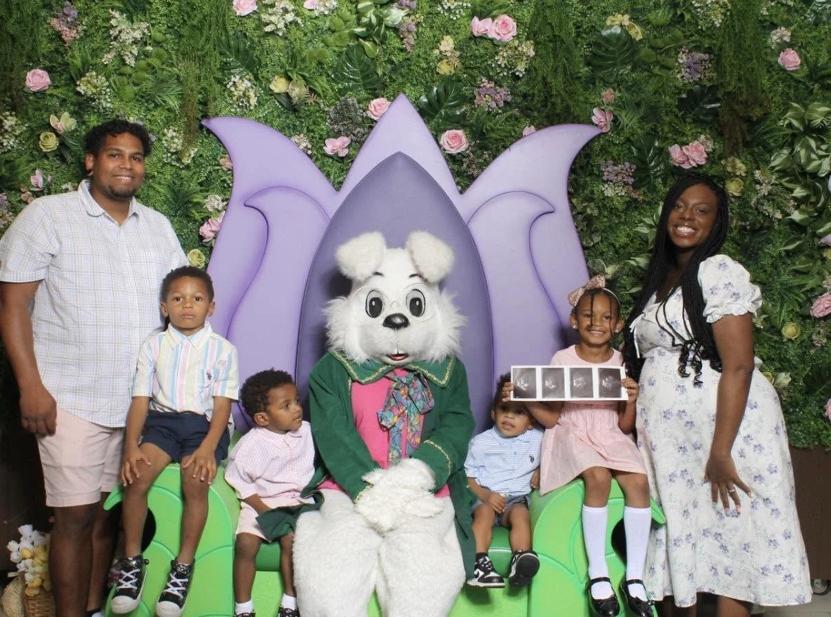 A family at Easter holding an ultrasound of triplets