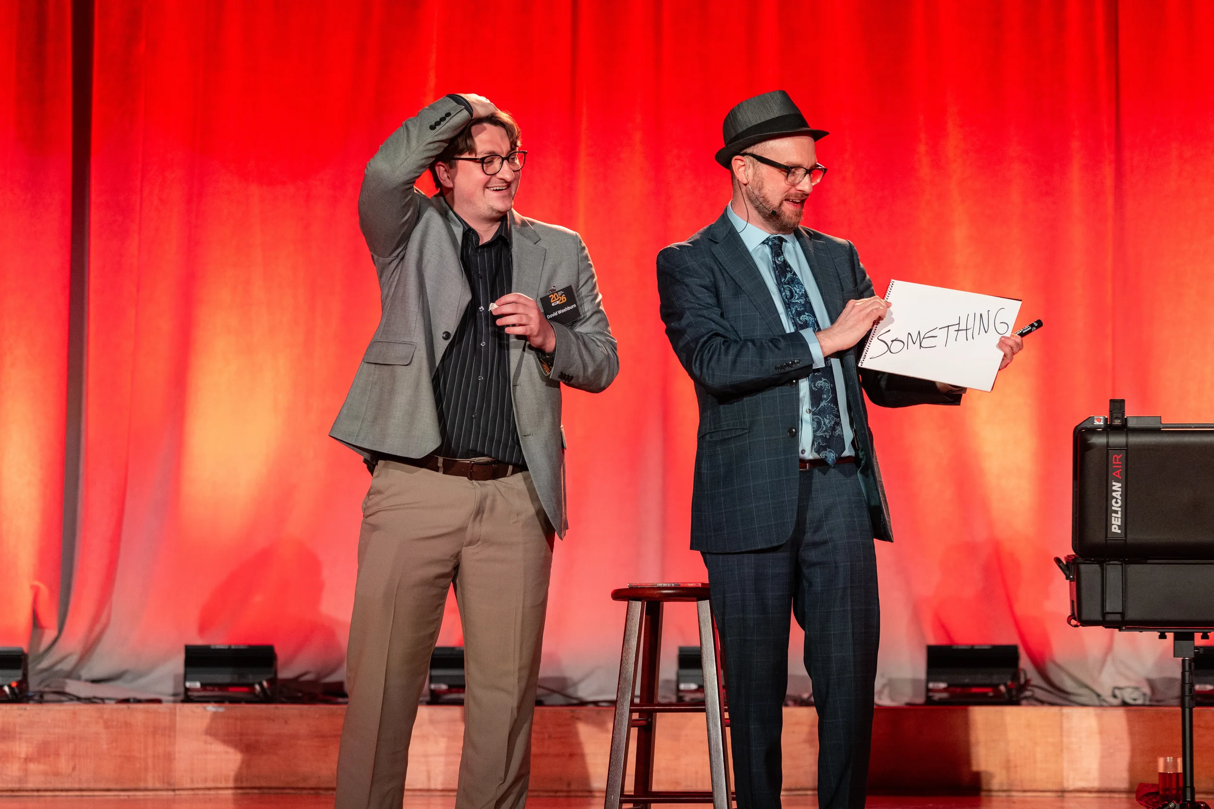 Two magicians performing on stage together at a live show