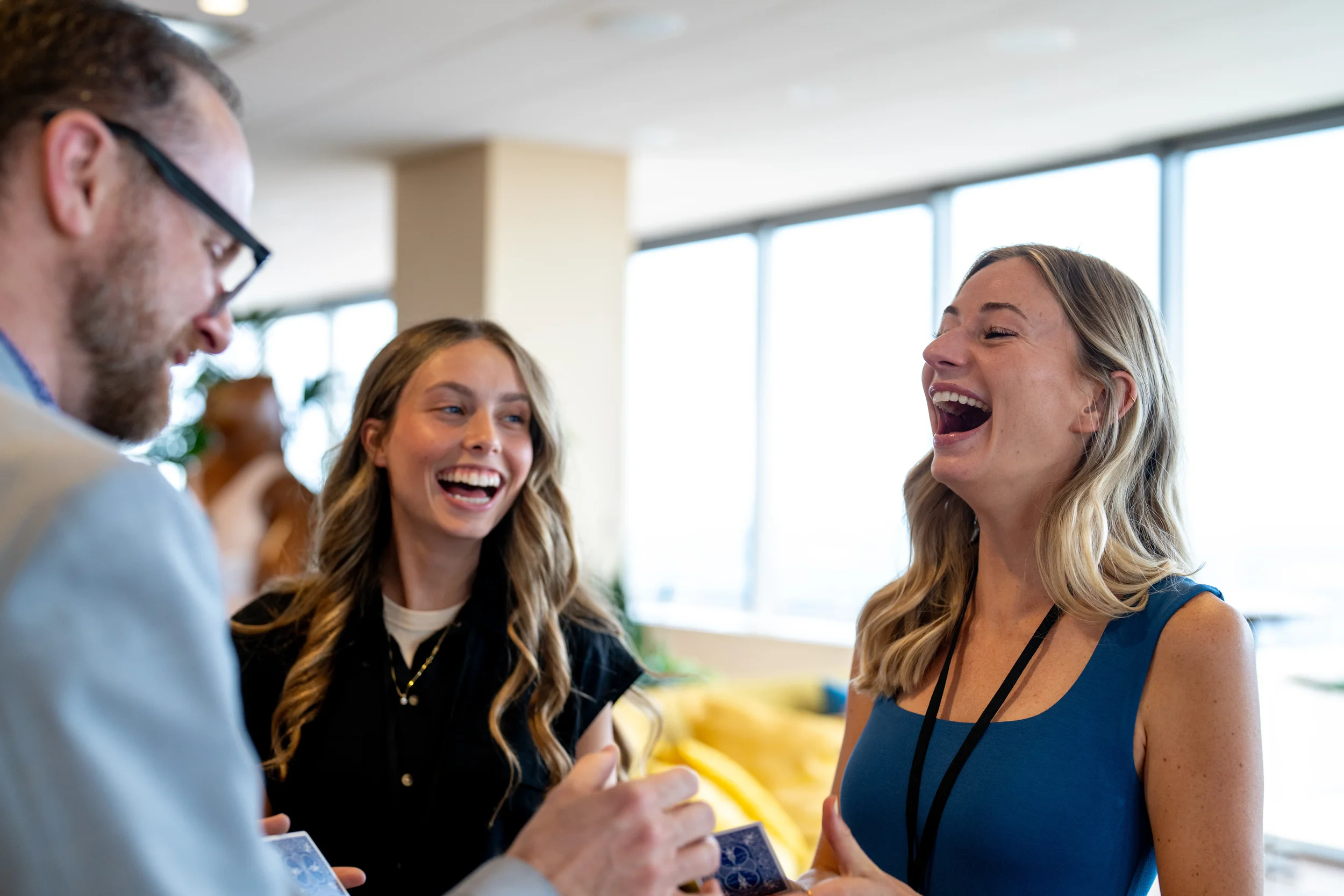 Two women laughing during a close-up magic performance