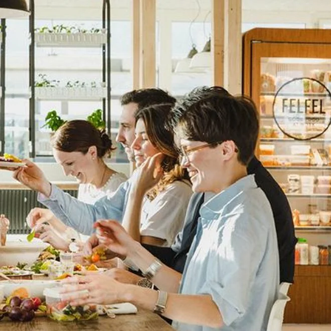 Team beim gemeinsamen Mittagessen neben dem FELFEL Kühlschrank