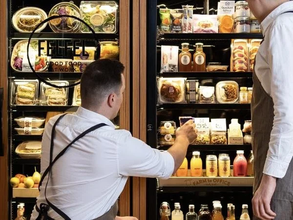 FELFEL Mitarbeiter bestückt den Kühlschrank im Büro