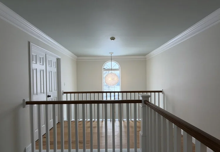 Painted upstairs landing with white trim and a pale blue ceiling
