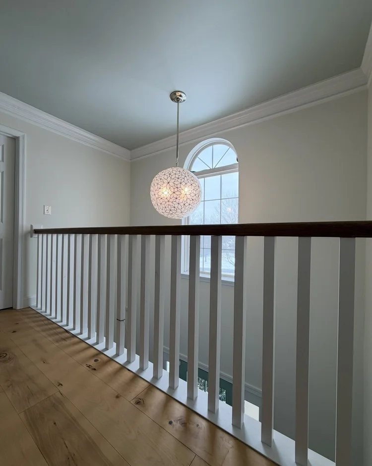 Interior painting with light walls, white crown molding, and stair railing