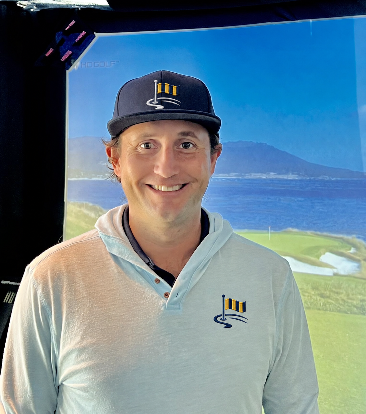 Coastal Golf Academy coach Ethan Castle wearing the academy's navy and gold logo