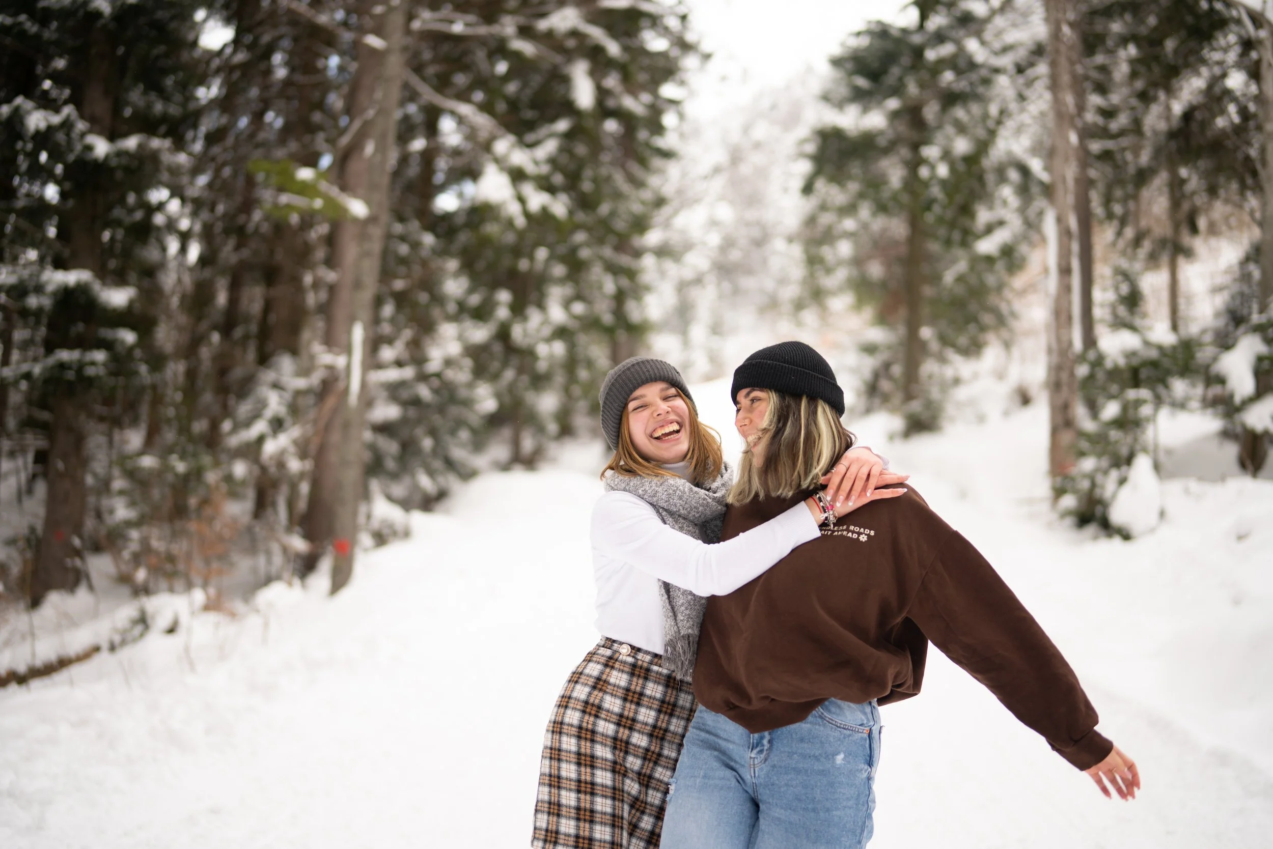 Two girls laughing together in winter