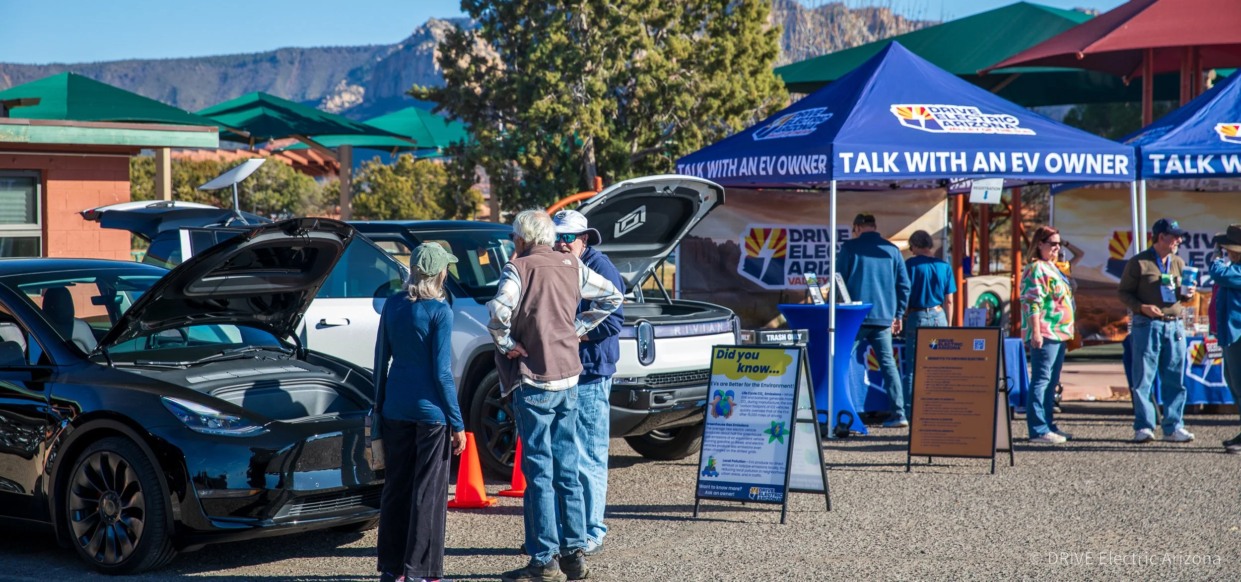 Electric vehicle owners and visitors gathering at a Valley of the Sun EVA event