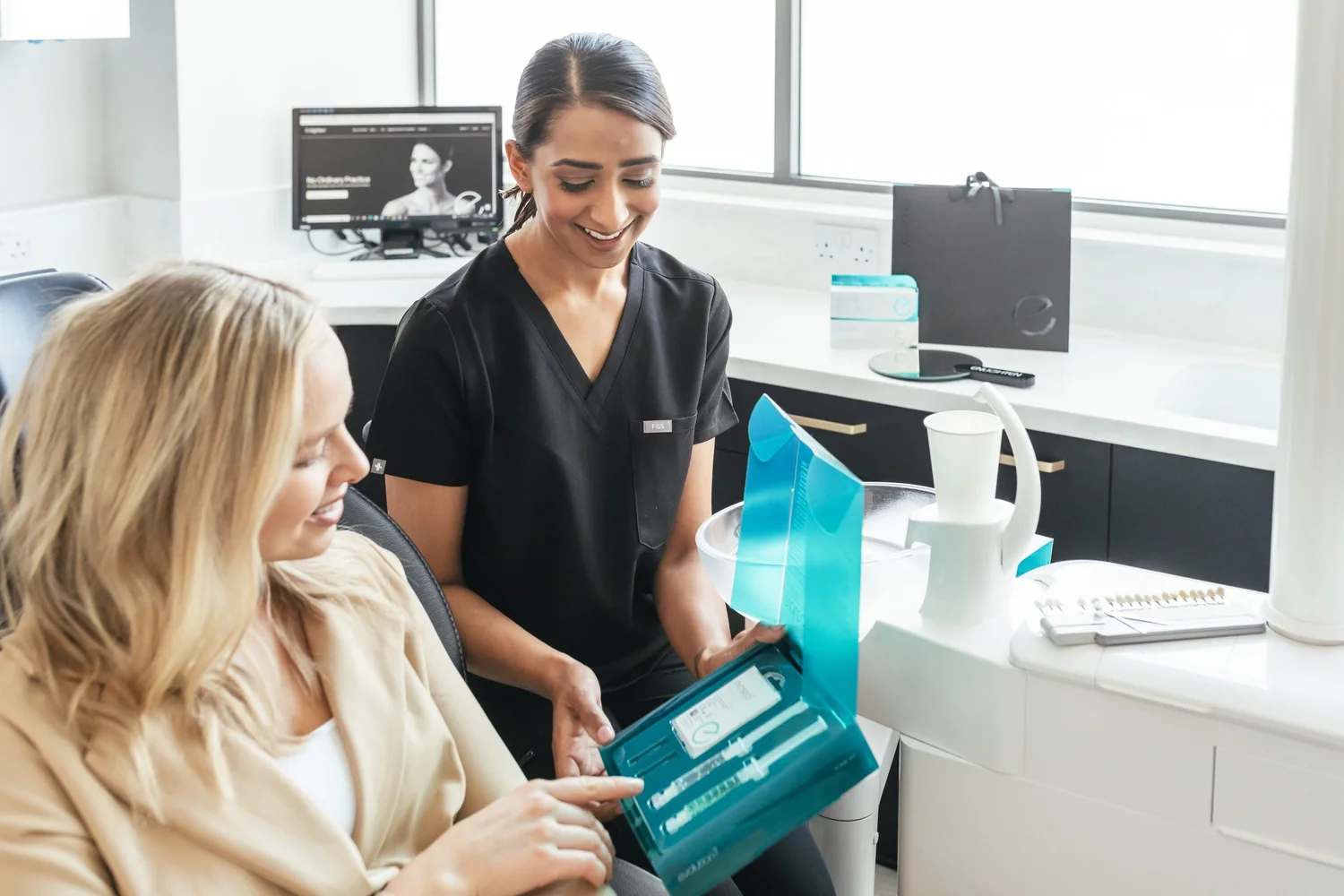Dr Tajel Patel explaining a whitening kit to a patient