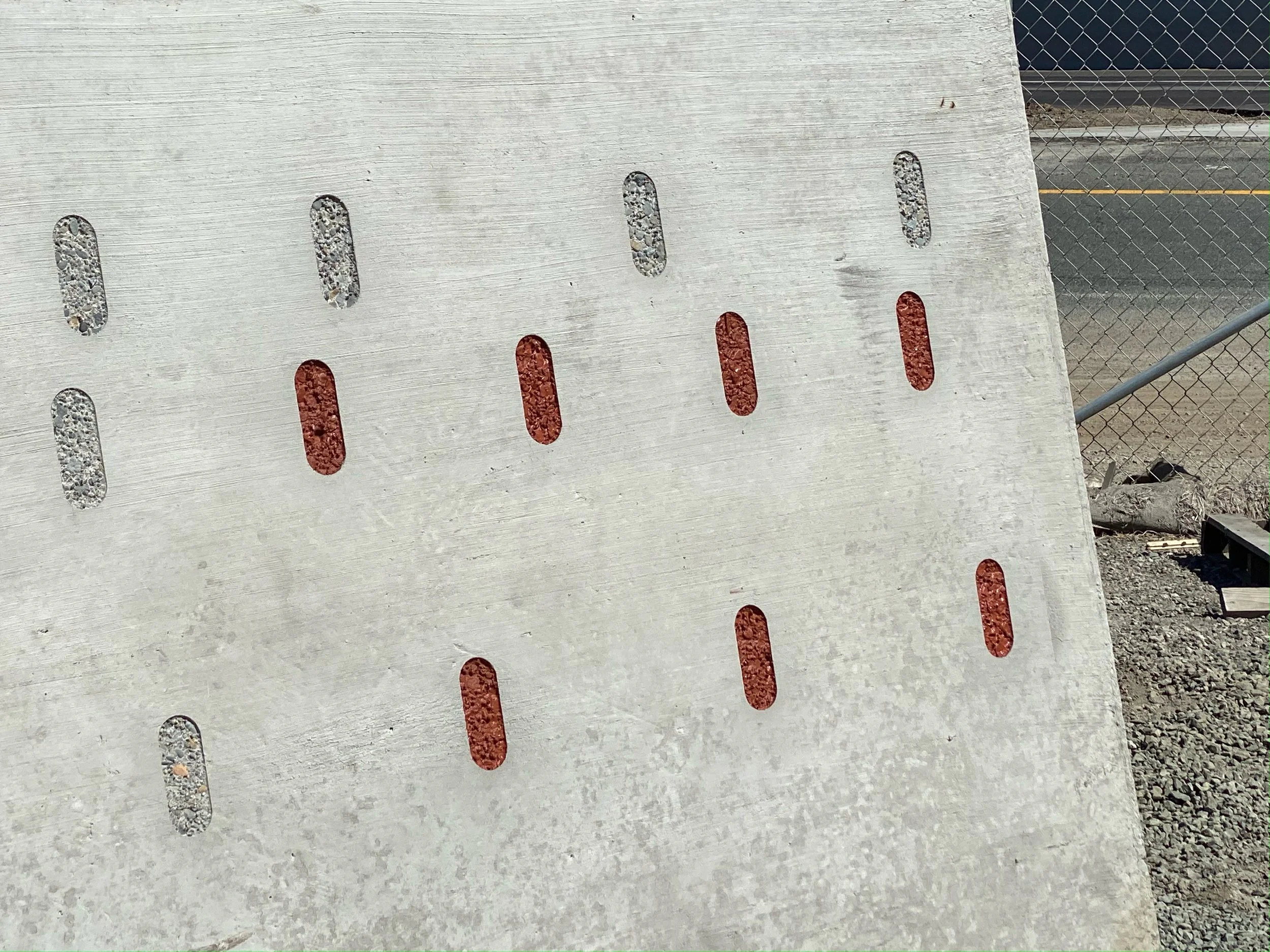 PDB concrete project photograph showing small areas of exposed aggregate against the surrounding concrete surface