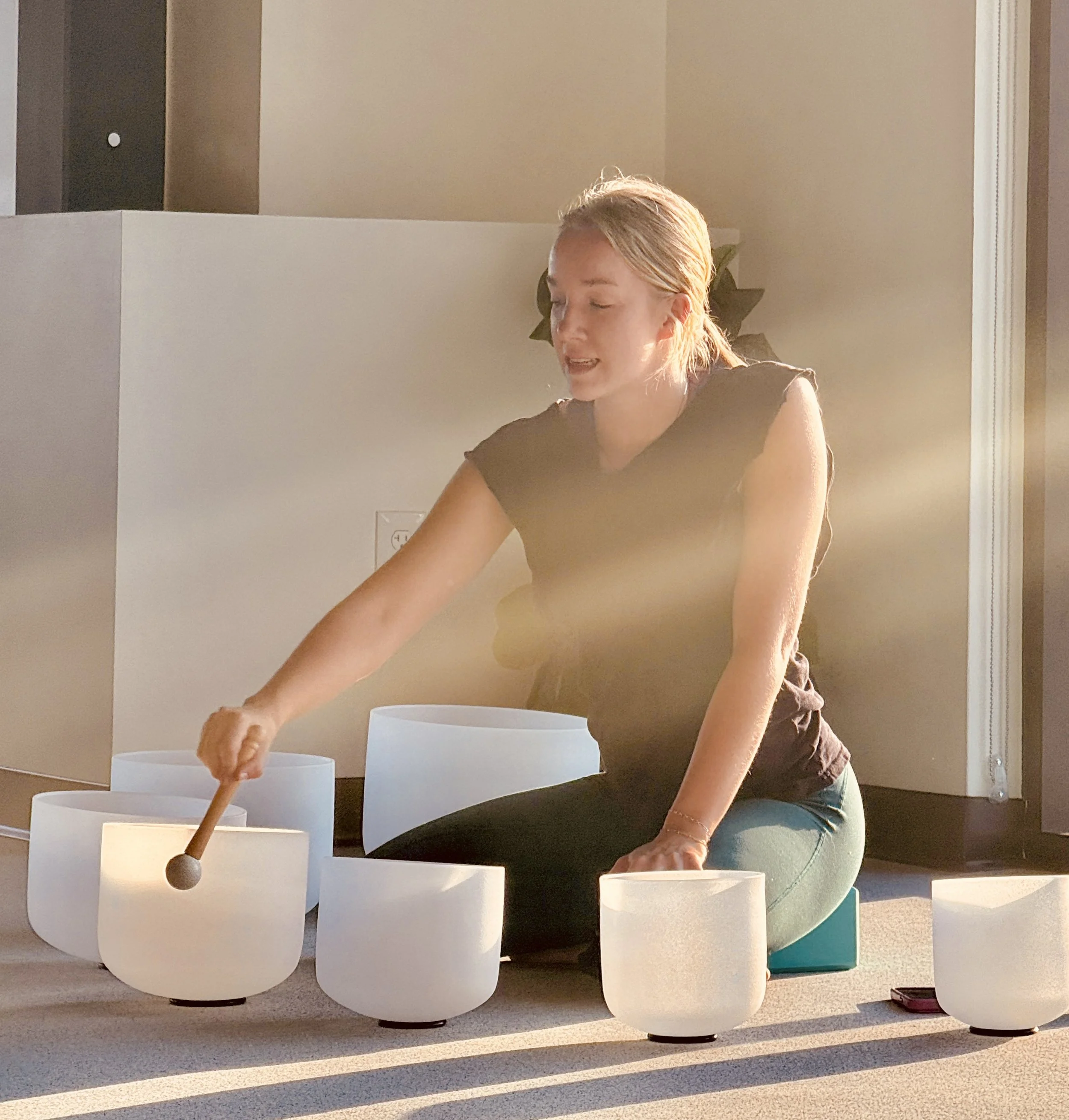 Jenna playing a crystal singing bowl during a corporate session