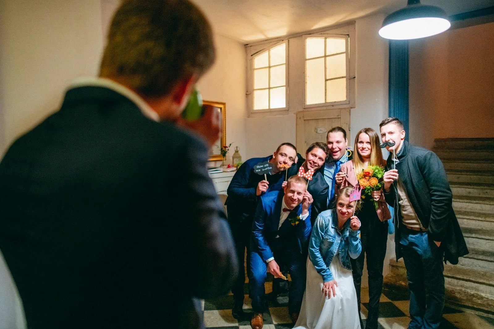 Skupinové selfie v interiéru zachycuje stísněnou, veselou blízkost.