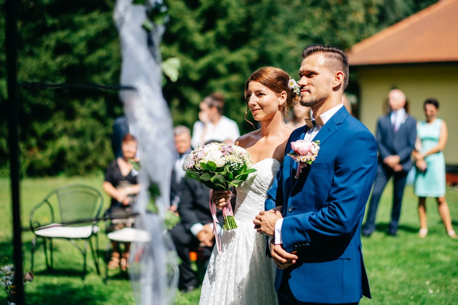 Blízký pohled na dvojici stojící před oddávajícím.
