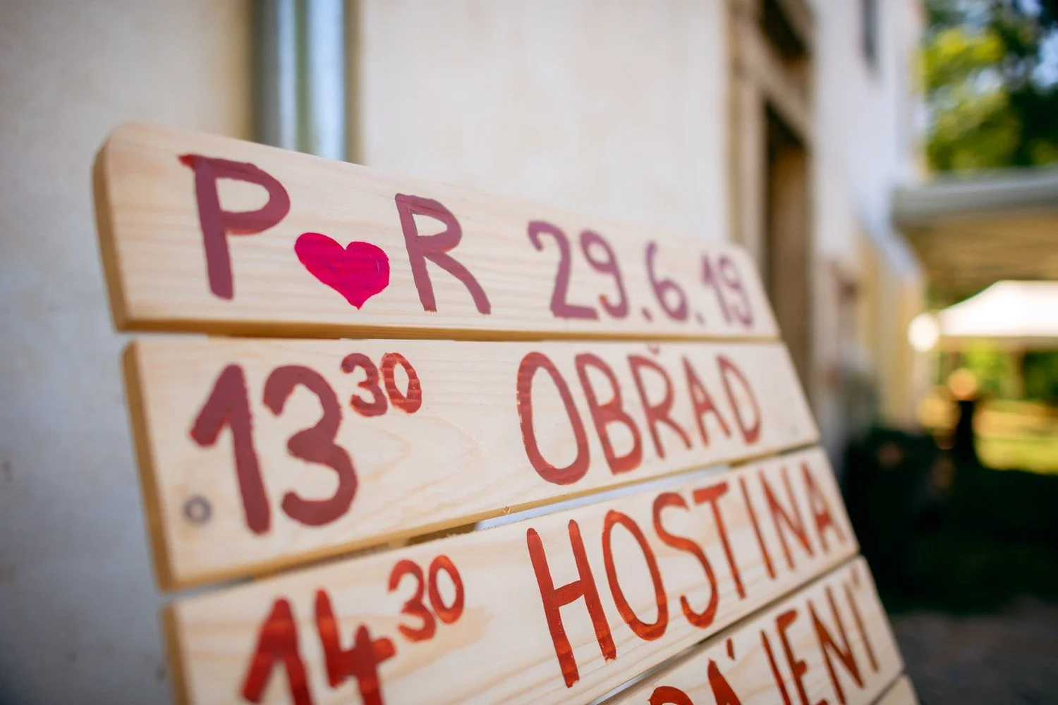 Ručně malovaná tabule uvádí iniciály P a R, datum 29. 6. 2019 a časy programu.