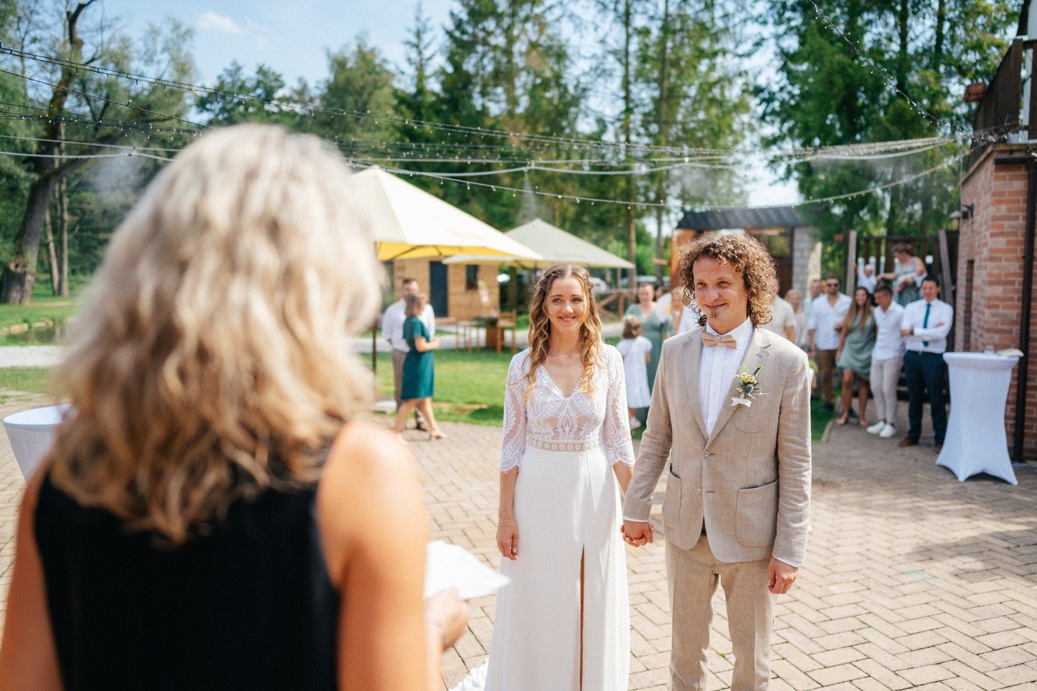 Anička a Norbert naslouchají ženě na dlážděném nádvoří