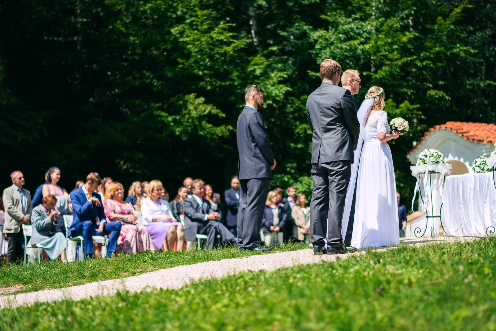 Detail mužských rukou při zapínání manžetového knoflíčku na bílé košili.