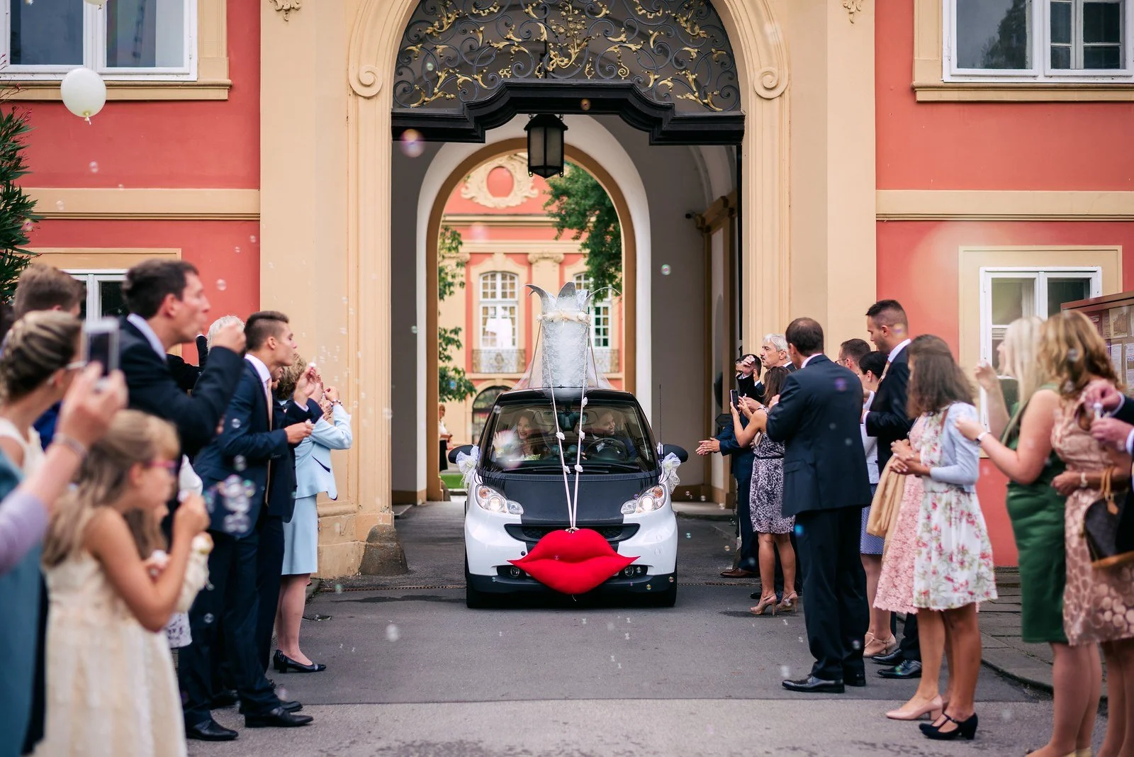 Hosté obklopují zadní část auta ozdobenou červeným srdcem.