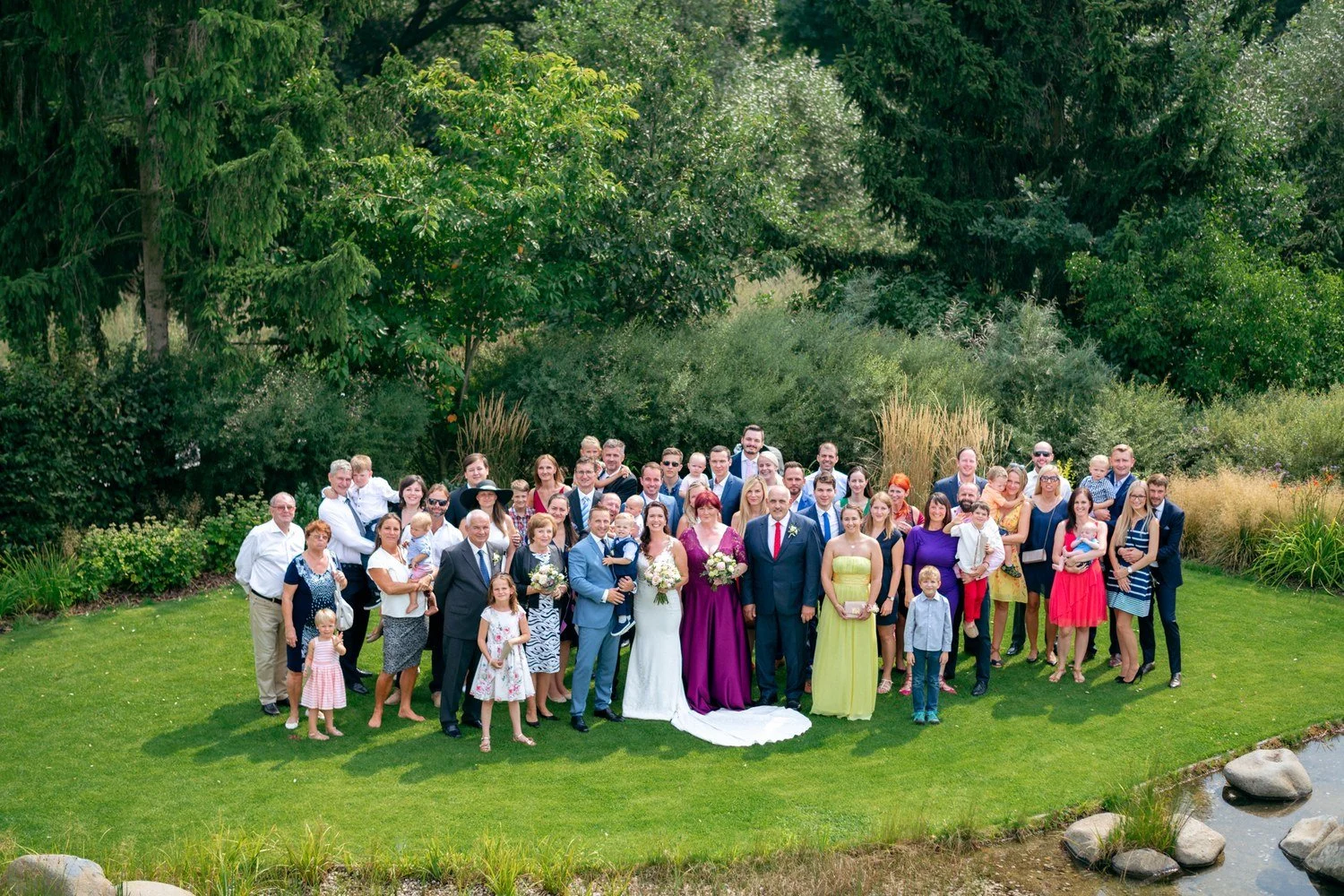 Společná fotografie svatebčanů na trávníku u Nového Rybníka.